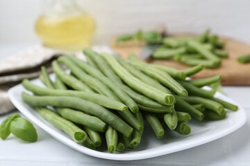Fresh green bean pods on white table, closeup