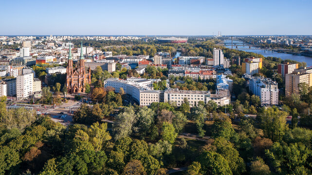 Aerial view of the towering St. Florian's Cathedral pierces the skyline amidst a tapestry of green trees and buildings, Warsaw, Poland.