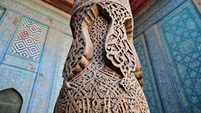 Intricate woodwork details on a column in Toshhovli Palace in Khiva, Uzbekistan