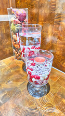 Pickles made in decorative glass jugs made of colorful vegetables on a wooden stand