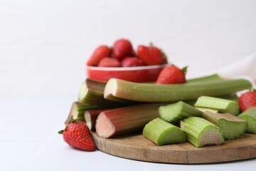 Fresh rhubarb and strawberries on white table, closeup