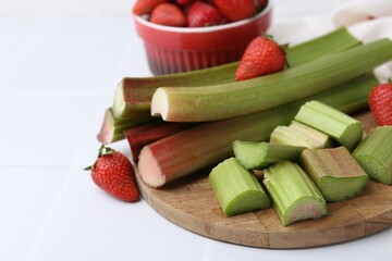 Fresh rhubarb and strawberries on white table, closeup