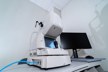 Ophthalmic imaging device in modern clinic. Diagnostic eye examination equipment with screen and control system in hospital.