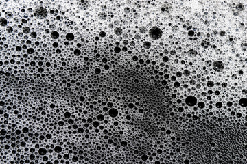 White foam bubbles detailed closeup form captivating texture and abstract pattern. fresh, pure liquid surface projects feeling of cleanliness and serene tranquility, with delicate, round spheres