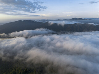 Majestic mountain peaks rise from tranquil cloud landscape. serene dawn atmosphere creates peaceful wonder, showcasing nature vast beauty. Aerial view provides captivating scene