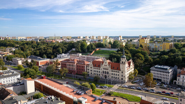 Aerial view of the vibrant red-brick and cream-colored buildings nestled among lush green trees, with cars parked nearby, Bydgoszcz, Wojew&Atilde;&sup3;dztwo kujawsko-pomorskie, Poland.