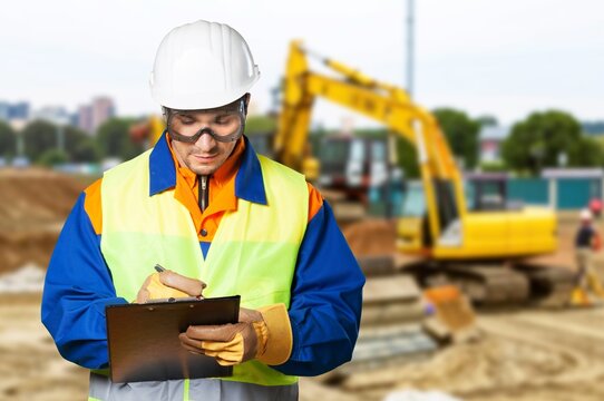 Industrial worker in helmet at production of excavator factory