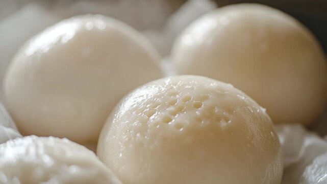 A close-up view of four balls of food in a bowl, often served as snacks or appetizers