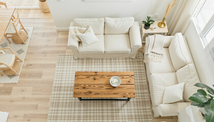 Aerial view of a bright and minimal living room with white sofas and wooden coffee table