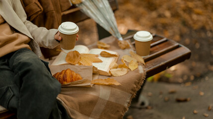 Autumn picnic scene with coffee and croissant