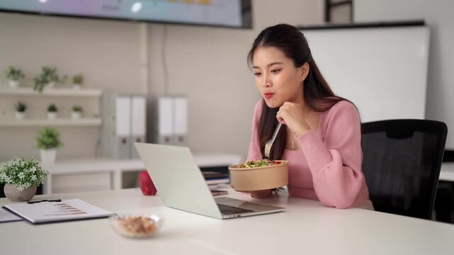 Asian adult woman professional enjoys healthy lunch working laptop office casual modern workspace productivity lifestyle wellbeing
