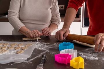 Unrecognizable family cutting cookies with christmas tree shape