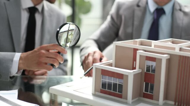 Two men are looking at a model of a building