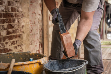 Maurer richtet einen Ziegel zu