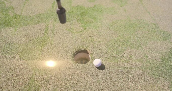 White golf ball rolling into view golfer kneeling grabbing it replacing flagstick finishing hole