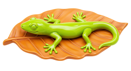 Green gecko figurine isolated on orange leaf, decorative ceramic animal for home decor on transparent background