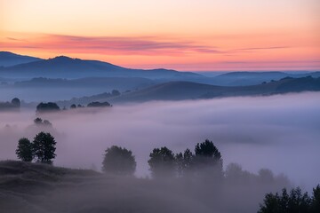 Fototapeta premium Stunning sunrise over misty hills with pink and orange sky creates a peaceful and serene atmosphere, perfect for travel and nature inspiration