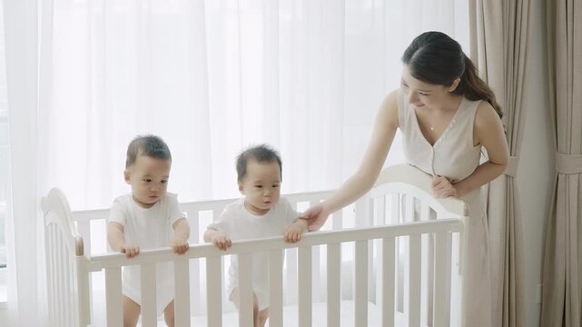 Happy mom taking care of her twin babies