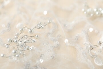 Fototapeta premium Beautiful lace fabric with sequins and pearls on beige background, closeup