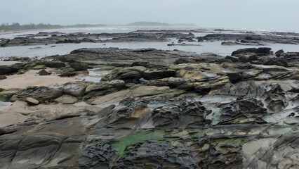 Dramatic Rocky Shoreline with Tidal Pools and Ocean Waves Under Overcast Sky