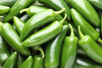 Many green jalapeno peppers as background, closeup