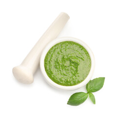Mortar of fresh pesto sauce, basil and pestle isolated on white, top view