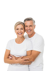 Fototapeta premium Happy caucasian couple, mid-40s-50s, blonde/grey hair, white t-shirts, embracing, smiling in transparent studio with copy space. Concept of love and companionship