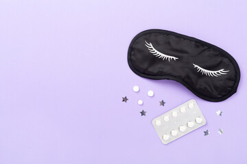 Sleeping mask with pills on color background, top view