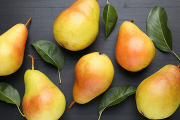 Many fresh pears and leaves on black table, flat lay