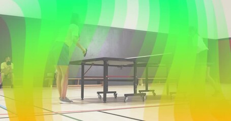 Two athletes bouncing ball and serving ball for table tennis rally in school gym for practice - Powered by Adobe