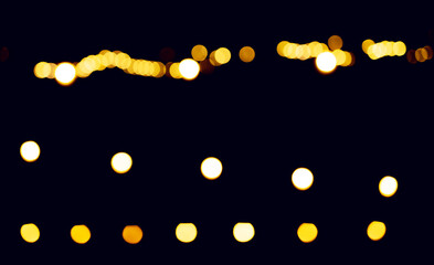 Bokeh lights glowing at night. Golden dots forming abstract pattern with blurred brilliance, dreamy