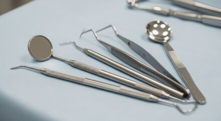 Collection of sterile dental instruments laid out on a blue cloth for a dental examination or procedure