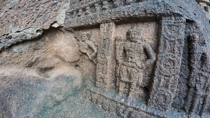 Weathered Ancient Rock-Cut Carving of a Colossal Buddhist Guardian Deity (Dvarapala) with an Intricate Snake Crown at the Entrance of Kanheri Caves, Mumbai