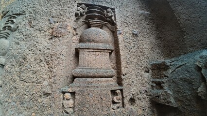 The Rich Texture and Fine Craftsmanship of Ancient Rock-Cut Reliefs Adorning a Wall in the Kanheri Cave Complex, Evoking Spiritual Heritage.