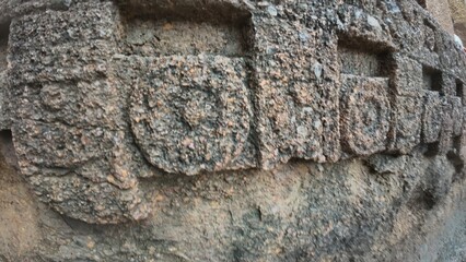 The Rich Texture and Fine Craftsmanship of Ancient Rock-Cut Reliefs Adorning a Wall in the Kanheri Cave Complex, Evoking Spiritual Heritage.
