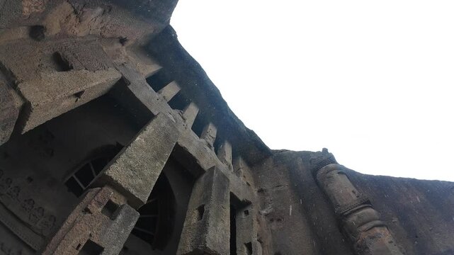 Dramatic Exterior View of the Grand Rock-Cut Buddhist Chaitya Hall Entrance (Cave 3) at Kanheri, Mumbai, Under an Overcast and Cloudy Sky