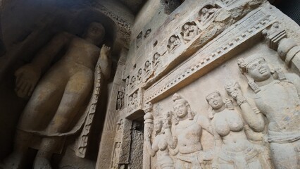 The Rich Texture and Fine Craftsmanship of Ancient Rock-Cut Reliefs Adorning a Wall in the Kanheri Cave Complex, Evoking Spiritual Heritage.