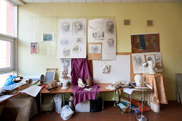 Creative mess. Large art studio with classic head sculptures, drawings, canvas and beautiful pencil sketches on the wall
