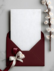 Elegant Invitation: A beautifully styled shot of a burgundy envelope, complete with a decorative bow, cradling a pristine white card against a soft backdrop of marble.