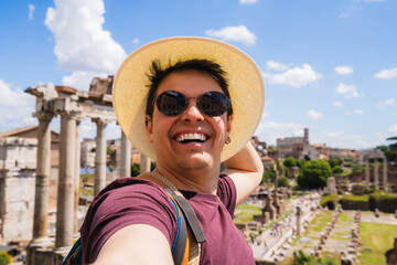 Happy man on vacation taking selfie enjoying travel at roman forum in rome
