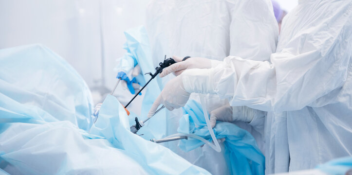 Surgeons performing laparoscopic surgery in operating room