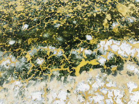 Aerial view of shimmering saline ponds painted in earthy hues, reflecting sunlight like scattered jewels across the landscape, Bay of C&Atilde;&iexcl;diz, C&Atilde;&iexcl;diz province, Andalusia, Spain.