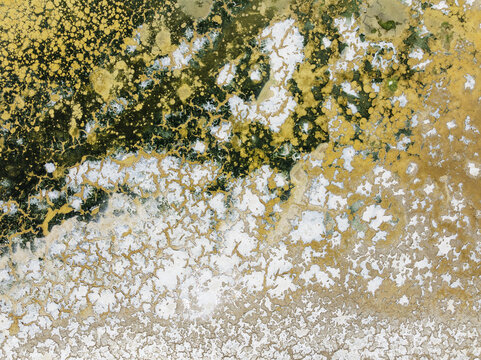 Aerial view of shimmering saline ponds painted in earthy hues, reflecting sunlight like scattered jewels across the landscape, Bay of C&Atilde;&iexcl;diz, C&Atilde;&iexcl;diz province, Andalusia, Spain.