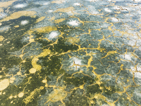 Aerial view of shimmering saline ponds painted in earthy hues, reflecting sunlight like scattered jewels across the landscape, Bay of C&Atilde;&iexcl;diz, C&Atilde;&iexcl;diz province, Andalusia, Spain.