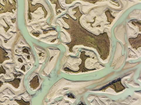 Aerial view of meandering waterways carve intricate patterns through the sandy expanses, creating a tapestry of turquoise against beige, Bay of CÃ¡diz, CÃ¡diz province, Andalusia, Spain.