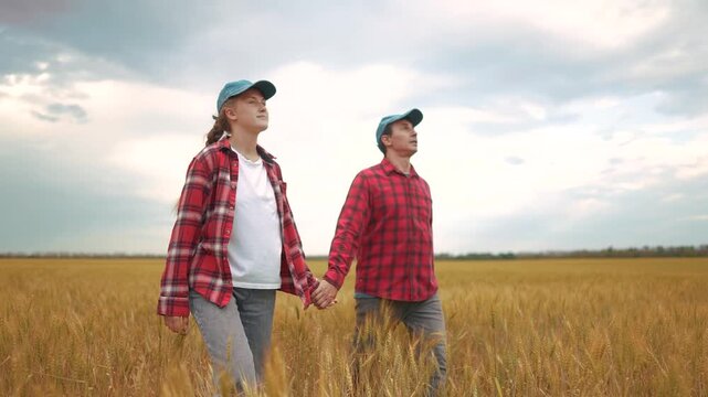 Family walking in a field of wheat. happy family kid dream concept. Father and daughter of a farmer. Father and daughter walking in a field of wheat. farming lifestyle business concept.