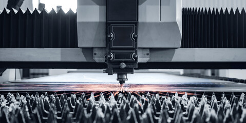 Laser cutting machine in industrial factory with bright sparks