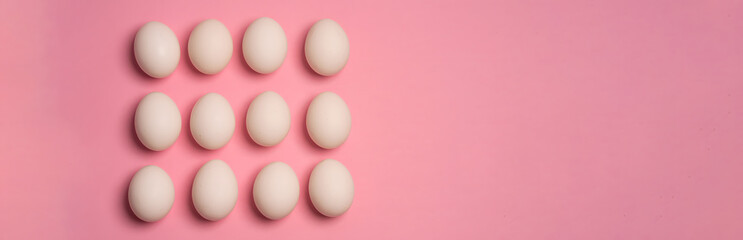 White chicken eggs neatly arranged in three-by-four grid on pastel pink background. Concept of food, breakfast, protein, organic farming and modern minimal flat lay.