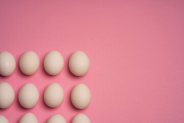 White Easter eggs on pink background. Easter elements. Easter background. Easter pattern. Top view. Flat lay. Minimal concept.
