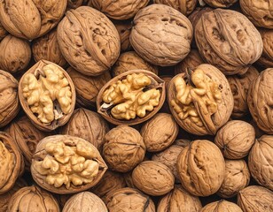 Close-up view of many walnuts, some whole and some cracked open, displaying the nutmeat inside